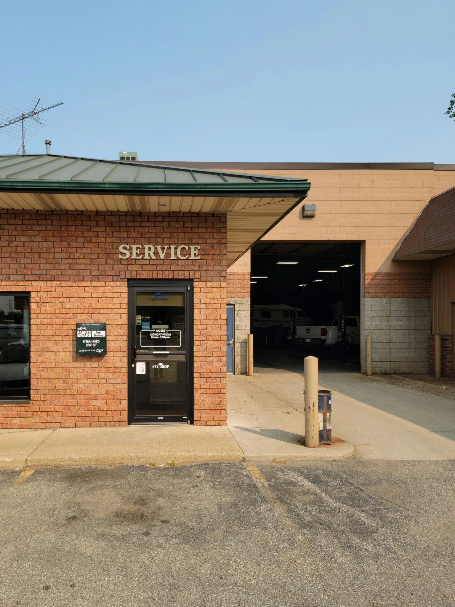 Parker Brake & Alignment service entrance — brick building with green canopy and an open service bay, West Side Grand Rapids